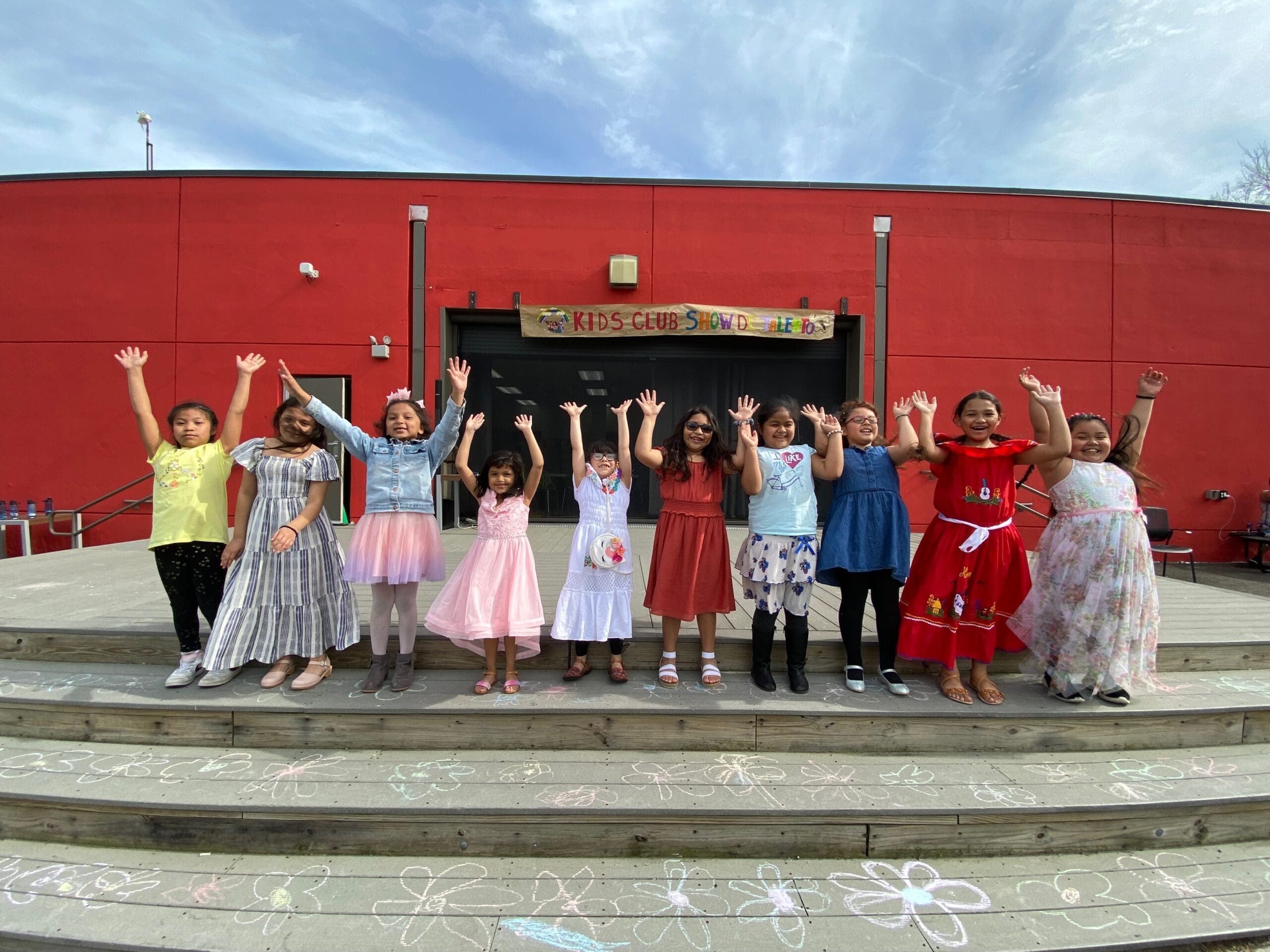 Children with hands raised during performance.